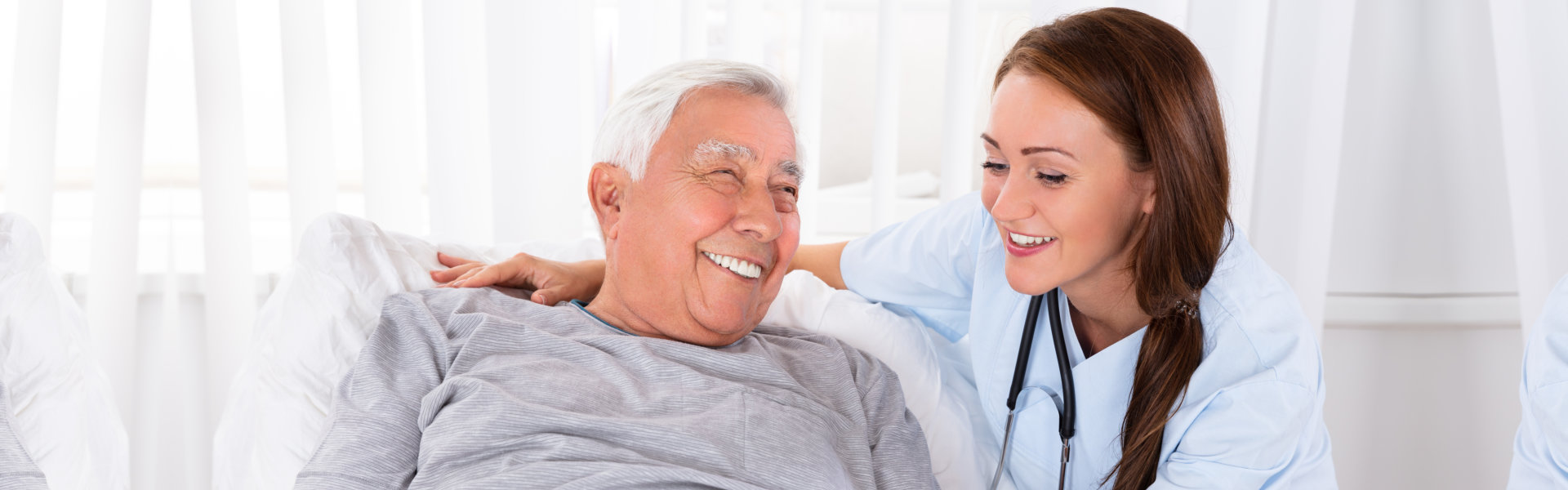 Elderly man and his caregiver smiling